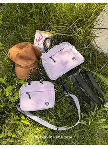 Detail of versatile lavender mini backpack and crossbody bag in outdoor grass setting