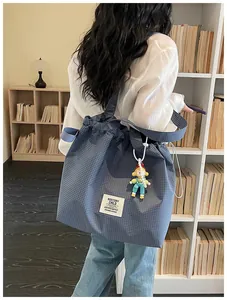 Back view of a blue grid canvas tote bag styled with a casual outfit in a library