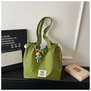 Casual green checkered canvas tote bag with drawstring closure and decorative charm