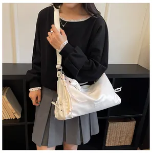 Detailed view of the stylish white shoulder bag worn by the model, showcasing chic daily design.