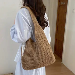 Vista detallada de bolso de hombro de paja veraniego, diseño casual con textura natural.