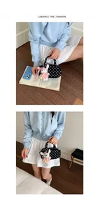 Detail view of Korean style polka dot bowling bag with cute plush rabbit pendant and casual look.