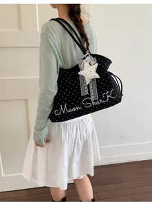 Detailed view of casual black polka dot tote bag with star pendant and embroidery lettering.