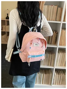 Zaino in tela rosa con graziosi motivi di stelle, spallacci a righe blu e design elegante.
