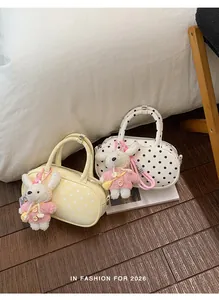 Detailed shot of Korean style polka dot bowling bag with cute knit bunny keychain accessory.