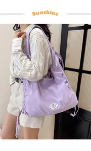 Vista detallada del bolso de hombro morado informal con cordón ajustable y etiqueta.
