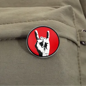 Premium circular metal enamel pin badge with rock on sign gesture on khaki backpack