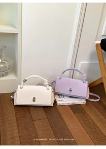 Elegante minimalistische Handtaschen in Weiß und Lila mit raffiniertem Knotengriff.