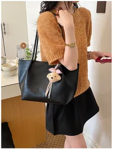 Large capacity black leather tote bag with teddy bear charm for women's commute.