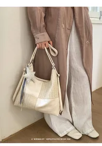 Elegante bolso tote beige para mujer con textura tejida y detalle de amuleto