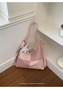 Vista detallada de un bolso mochila sofisticado de cuero trenzado rosa con dije de estrella.