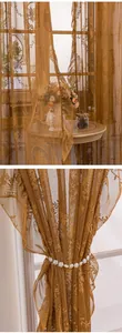 Détail de rideau en dentelle française avec broderie florale délicate et embrasse de perles.