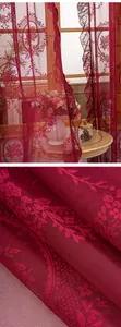 Vue détaillée d'un rideau en tulle de dentelle rouge avec motifs floraux élégants.
