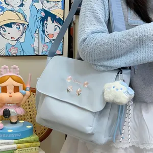 Light blue canvas messenger bag with floral embroidery and cute plush pendant casual tote