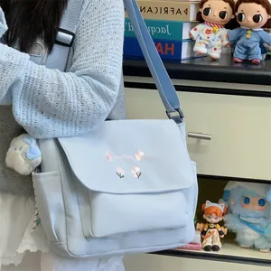 Casual light blue canvas shoulder messenger bag for women with cute floral embroidery design.