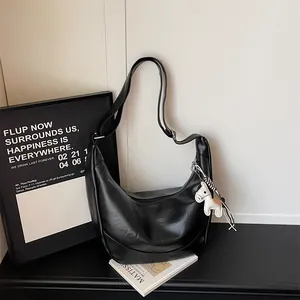 Black leather hobo shoulder bag for women, trendy crescent dumpling bag with cute horse charm.