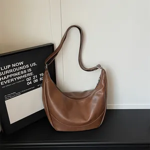 Brown PU leather hobo shoulder bag detail showing smooth curve, zipper and strap design.