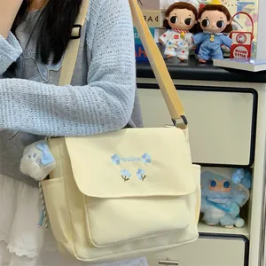 Casual yellow canvas crossbody bag with blue floral embroidery, stylish student commuter shoulder bag.