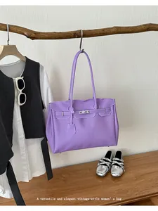 Detailed view of the elegant purple tote handbag hanging in a modern styled room scene.