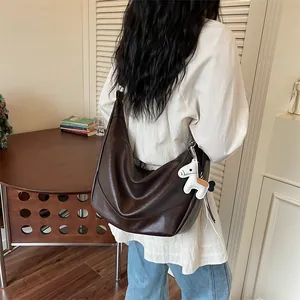 Brown slouchy hobo shoulder bag for women, trendy crossbody dumpling bag with cute white horse charm.