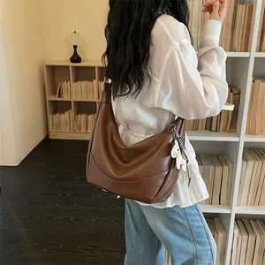 Brown PU leather hobo shoulder bag for women, trendy dumpling crossbody bag with cute charm.