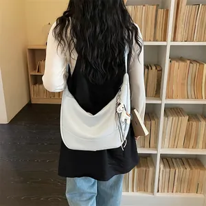 Minimalist leather shoulder bag detail view with cute horse charm and soft dumpling design.