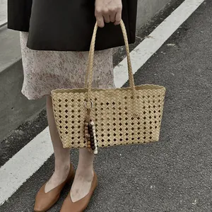 Stylish beige woven tote bag for women, large capacity hollow shoulder bag for summer commute.