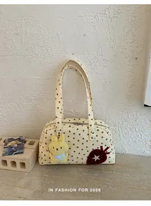Sac bandoulière Boston en toile à pois chic avec peluche de lapin et écusson fraise.