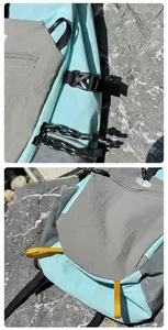 Close-up of color-blocking nylon backpack with buckle and zipper details on rock.