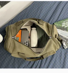 Green canvas travel duffel bag detail showing large capacity, durable fabric and zipper closure.