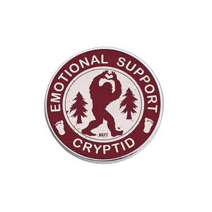 Pin de esmalte redondo con diseño de Bigfoot y texto 'Emotional Support Cryptid'.