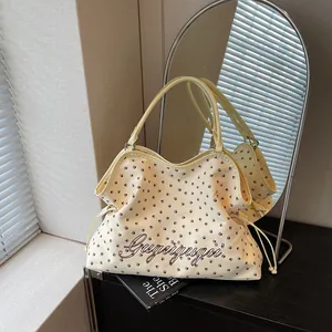 Vue détaillée de l'élégant sac cabas beige doté d'empreintes de pattes et de doubles poignées.