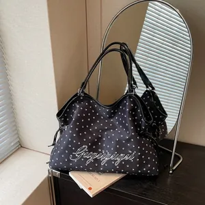 Vue détaillée du sac cabas en toile noire avec imprimé empreinte de patte blanche et style.
