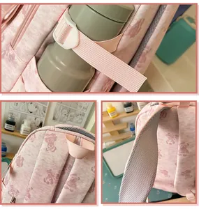 Close-up of pink backpack with bear patterns, showing shoulder strap and side pocket details.