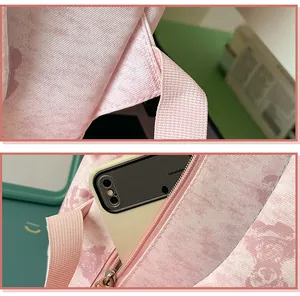 Close-up of pink bear print backpack showing strap stitching and zipper pocket detail