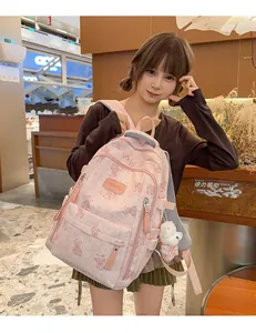 Asian girl modeling a cute pink backpack with bear prints and a plush doll accessory
