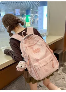 Back view of a pink school backpack with cute bear prints worn by a student model