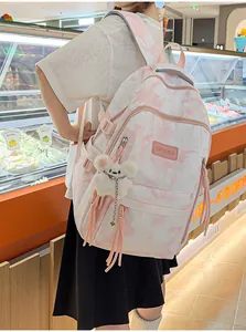 Back view of a trendy pink tie-dye schoolbag featuring a fluffy charm and tassels details