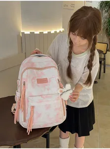 Detail view of pink tie-dye high-capacity school backpack with tassel