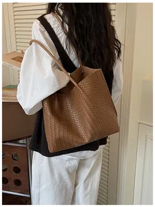 Vue détaillée du sac cabas en cuir tressé marron, accessoire élégant pour le travail.