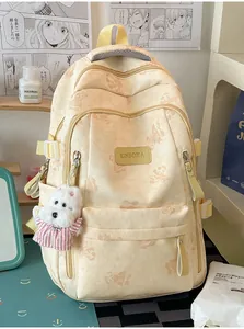 Detail view of cream student backpack with cute bear prints and dog plush pendant