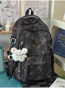Detailed view of a stylish grey tie-dye student backpack with a cute plush mouse keychain.
