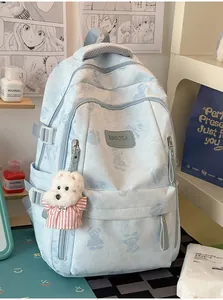 Detail of light blue bear print backpack with white dog plush charm and logo plate