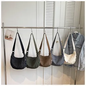 Detailed view of multi-color nylon waterproof plaid dumpling shoulder bags on rack.