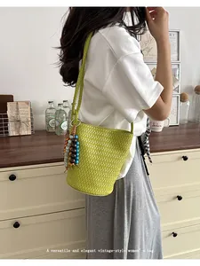 Green woven leather bucket bag with braided strap and charm for women summer style