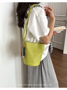 Classic woven leather bucket bag for women, stylish underarm shoulder bag with beaded charm.