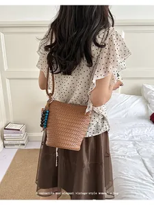 Detail view of the elegant brown woven shoulder bag, showcasing retro design and bead charms.