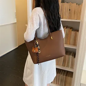 Casual large capacity brown tote bag with cute bear pendant, stylish daily shoulder bag for women.