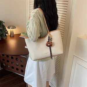 Stylish large capacity beige tote bag for women with brown trim and cute bear keychain.