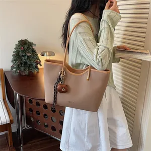 Detail view of the casual large capacity women tote bag with cute bear pendant in summer.